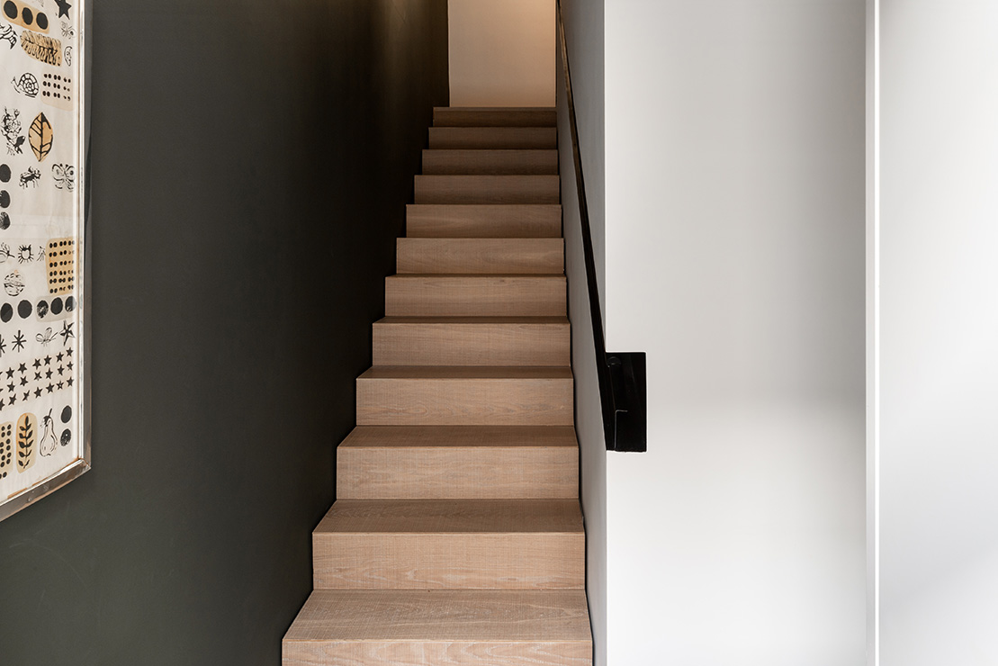 A timber stair with a recessed handrail leads up to the bedrooms.