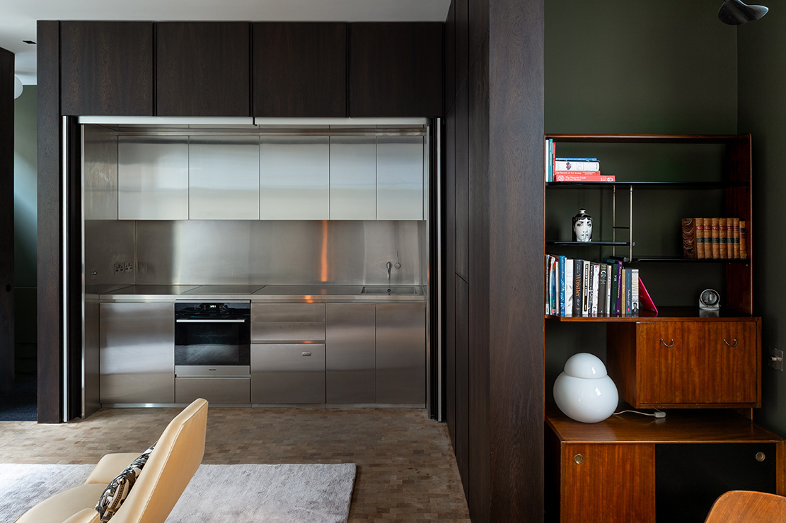 The steel kitchen can be hidden from the living space with bi-folding timber panels.